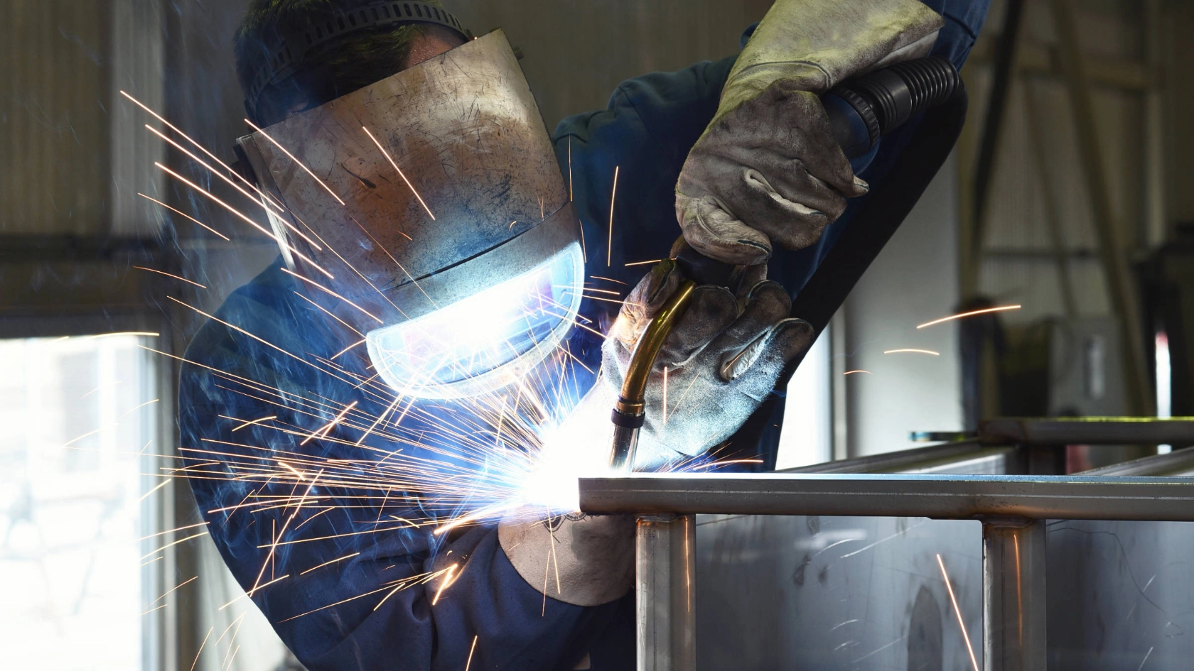 Ein Schweißer arbeitet an einer Metallkonstruktion.