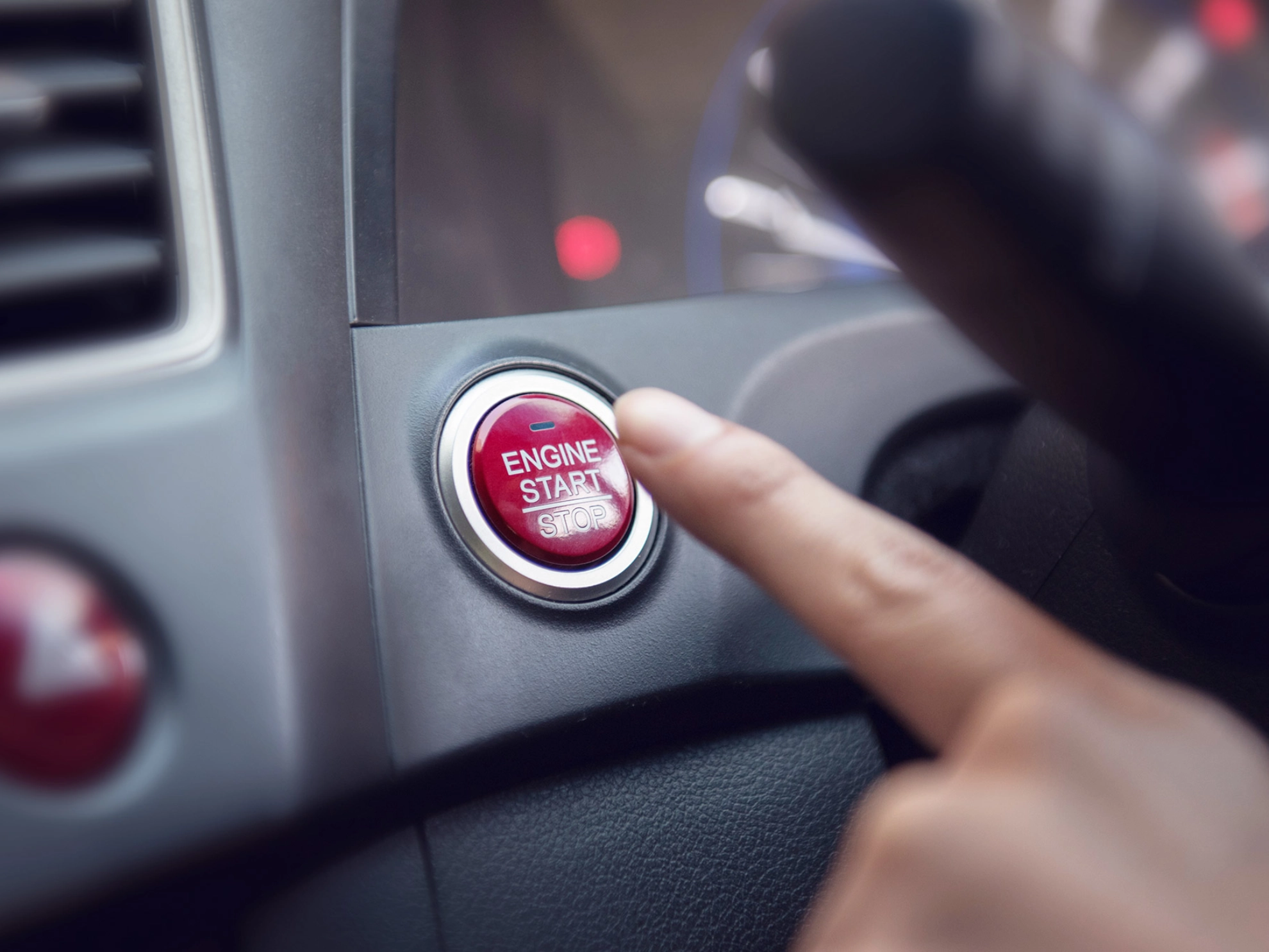 Nahaufnahme eines Fingers, die die Auto-Motor-Start-Taste drückt