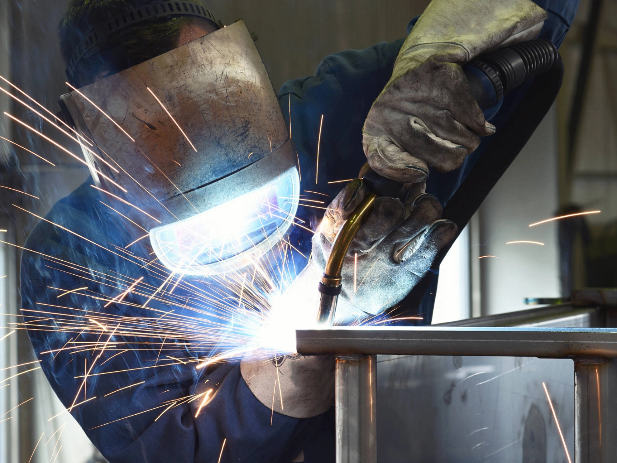 Ein Schweißer arbeitet an einer Metallkonstruktion.